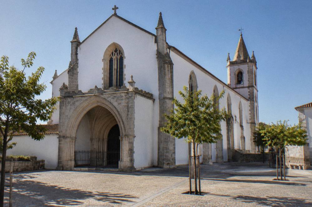 The Gothic interior of the Igreja de São Francisco in Évora with tall stone pillars and a vaulted ceiling