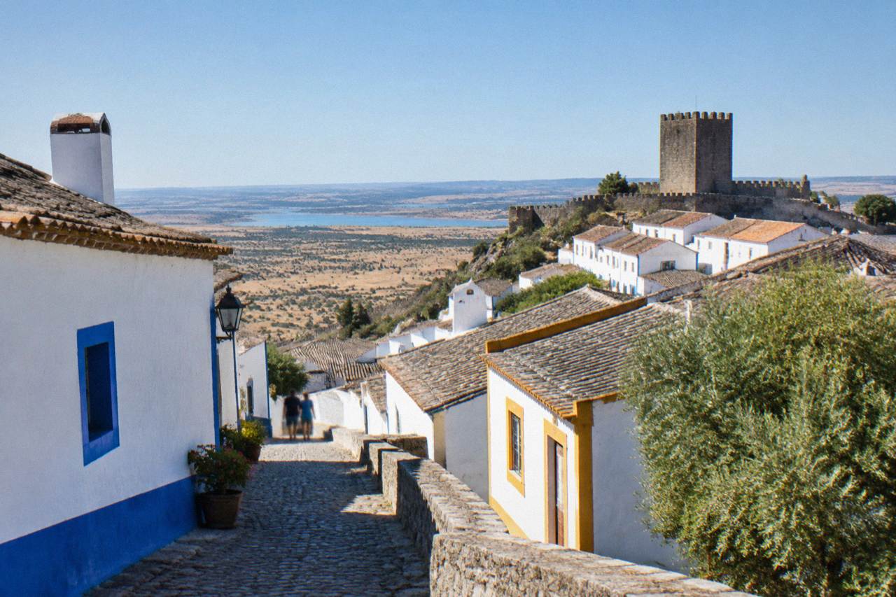 White-washed Alentejo hill town with a castle tower above golden plains