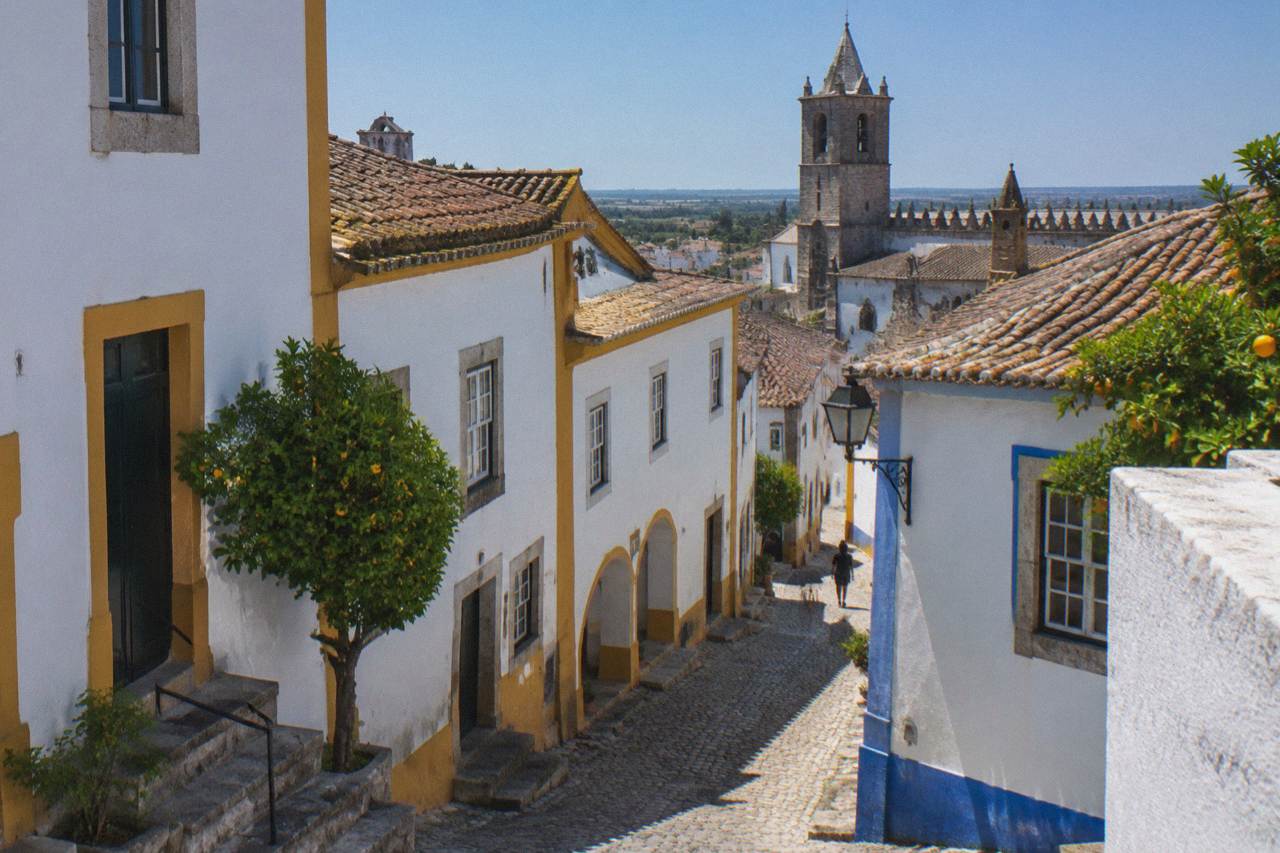 Golden limestone buildings and a church tower inside the walled centre of Évora