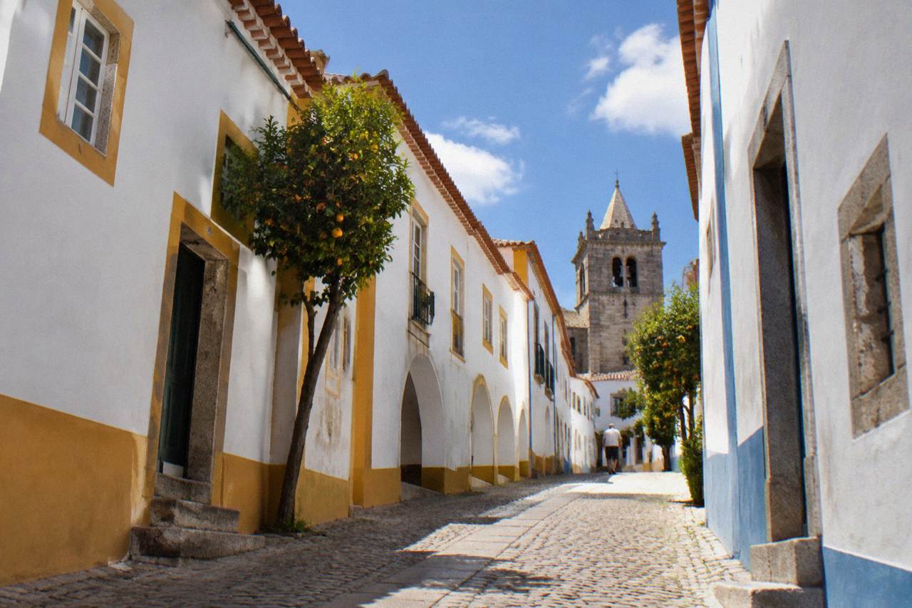 Medieval houses and an old church tower inside the walled historic centre of Évora on a bright afternoon