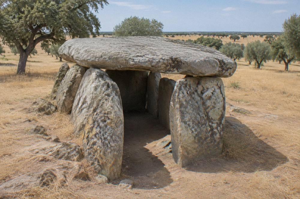 A massive stone chamber of the Great Dolmen of Zambujeiro under an open sky in the Alentejo