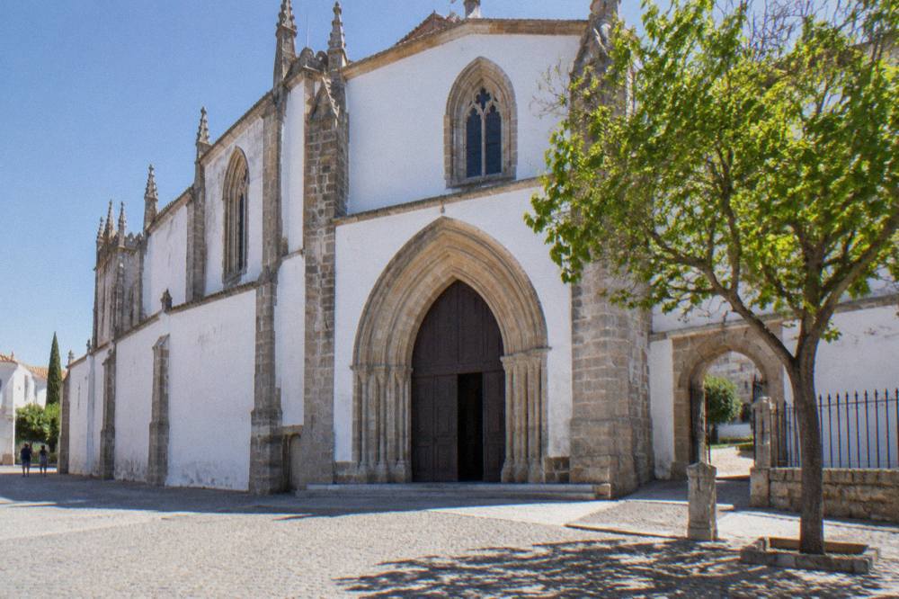 Exterior of the Igreja de São Francisco in Évora on a sunny day, with the entrance to the Chapel of Bones museum
