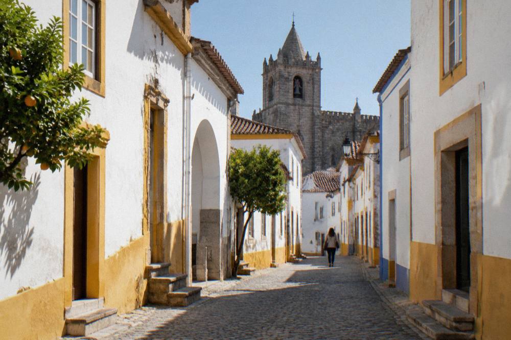The exterior of a Gothic church in Évora's historic centre, with a bell tower above narrow streets