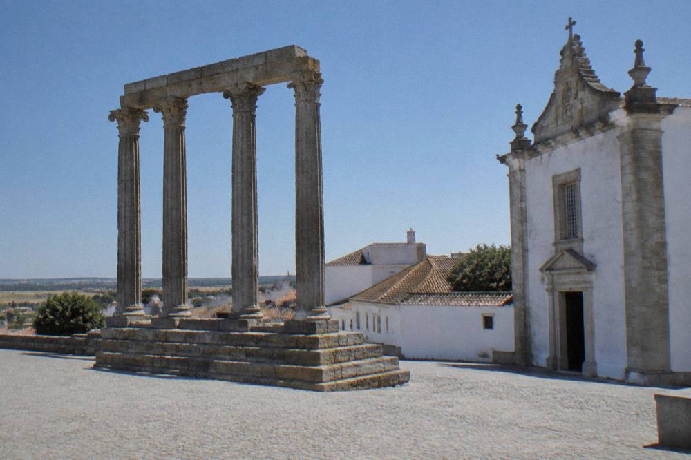 The Roman temple of Évora rising on its stone platform above the historic centre rooftops