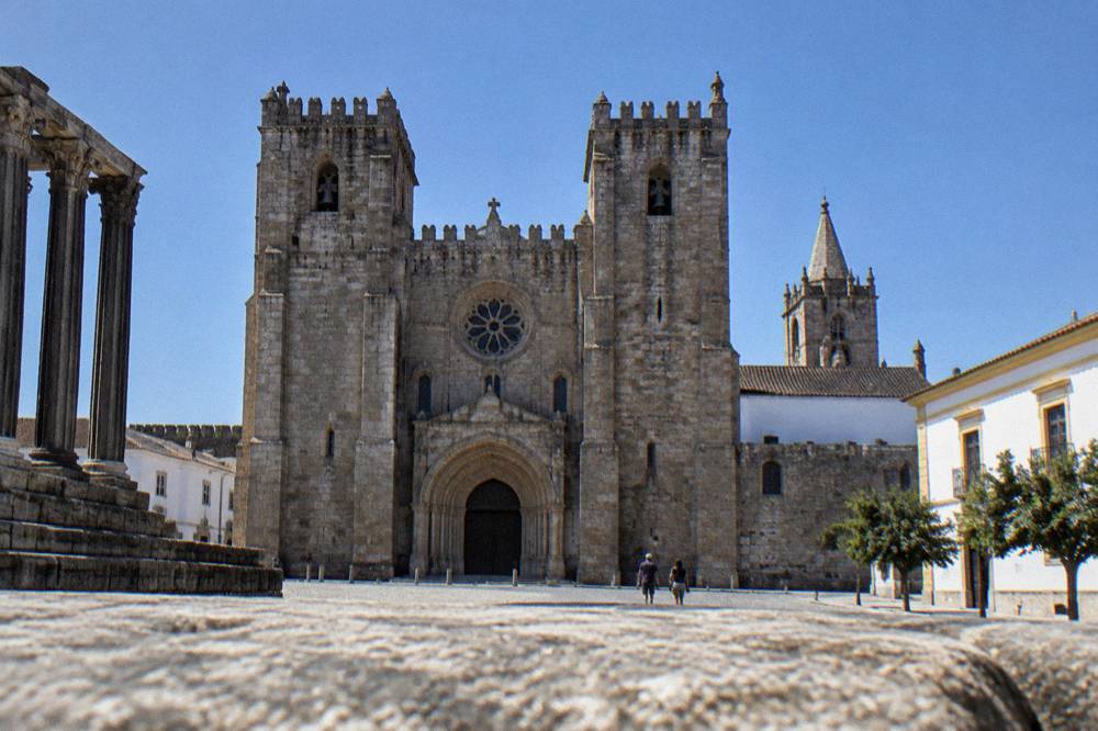 The granite west front of Évora cathedral seen from the square beside the Roman temple