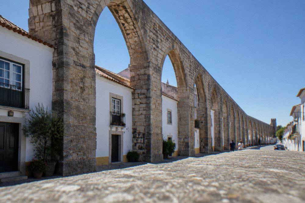 The arches of the Água de Prata aqueduct entering the eastern side of Évora with houses built between the piers