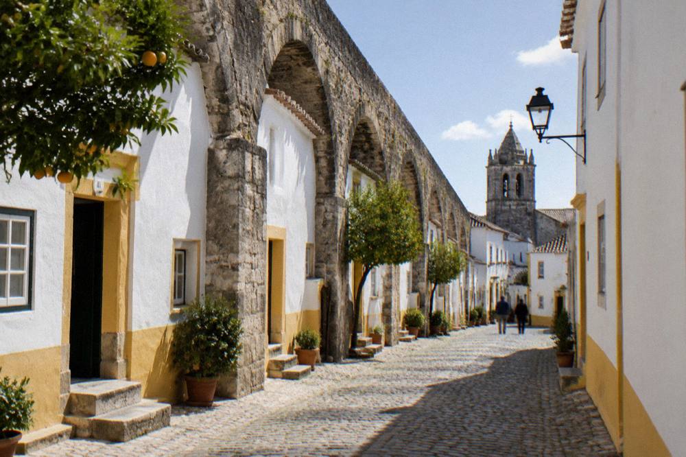 Houses built into the arches of the aqueduct on a narrow street in Évora