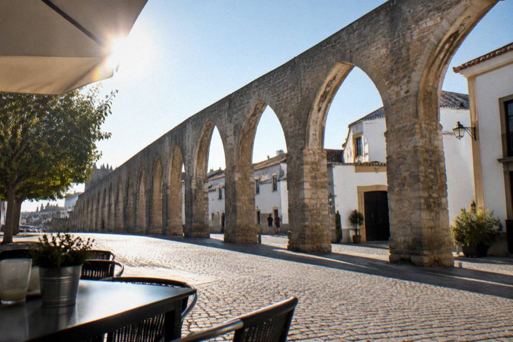 The aqueduct arches seen from a café terrace in a small square in Évora
