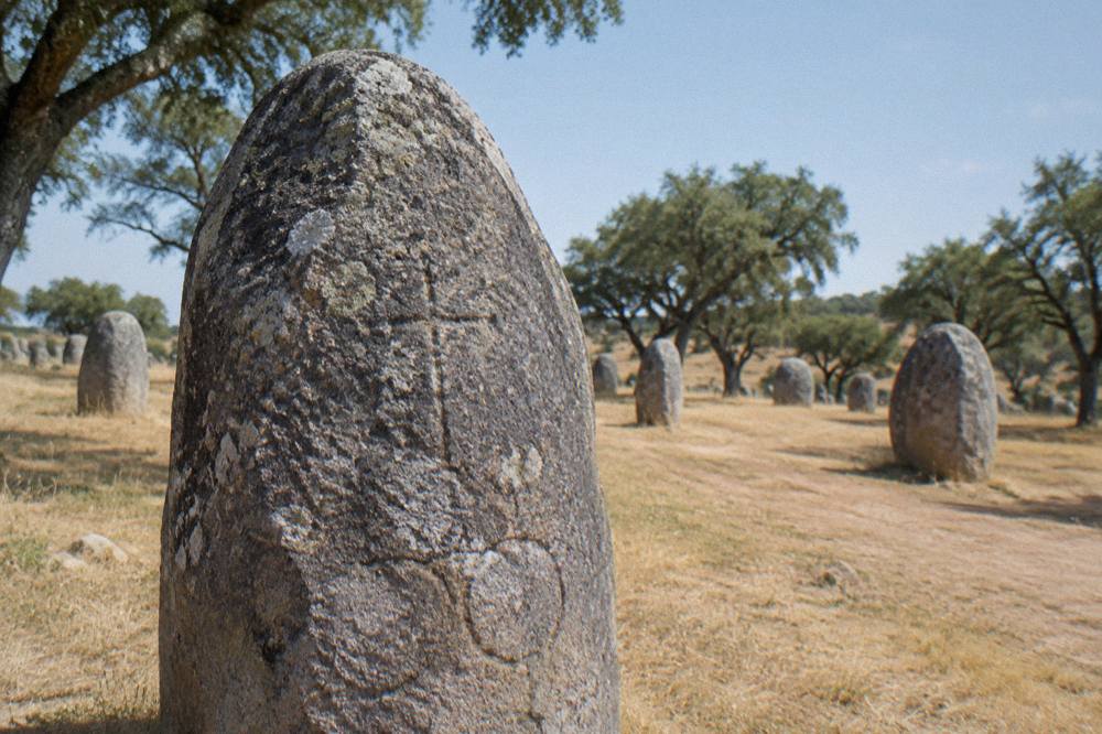 Close view of a weathered standing stone with faint carved markings at the Almendres cromlech