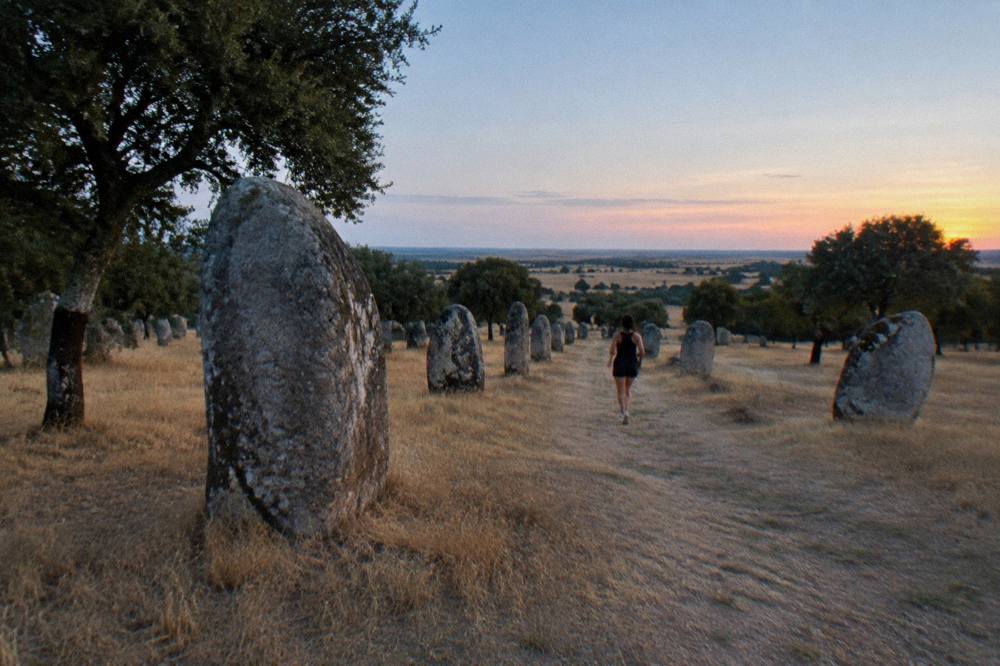 Sunset light over the Almendres standing stones with the wide Alentejo plain beyond