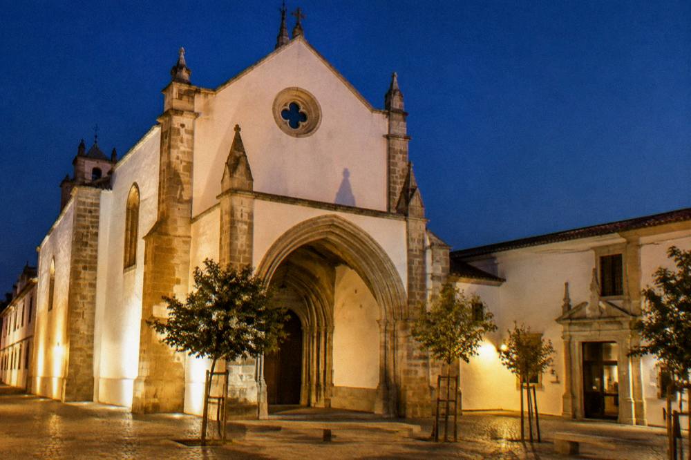 The evening facade of the Igreja de São Francisco in Évora under warm light, with the museum entrance visible at the side