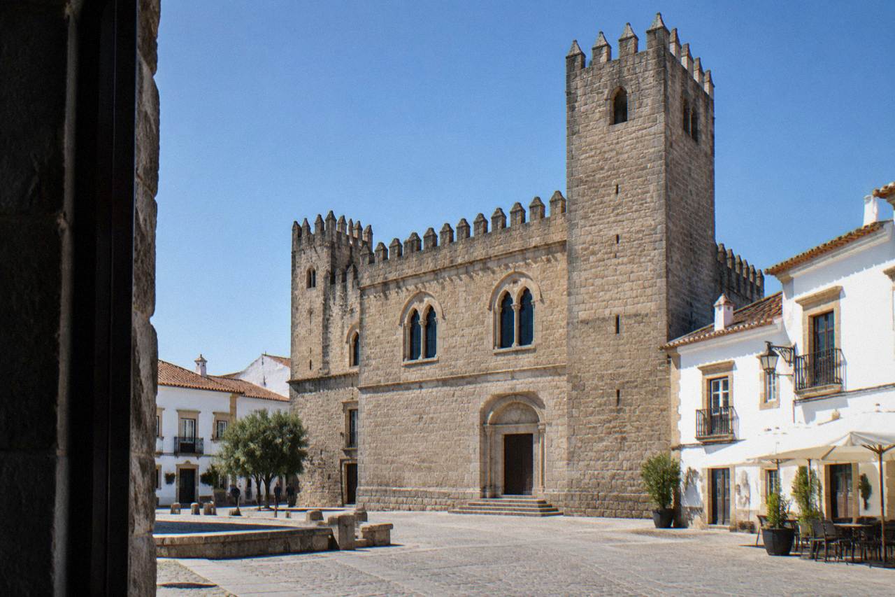 A historic palace facade with towers rising above the rooftops of Évora's old centre