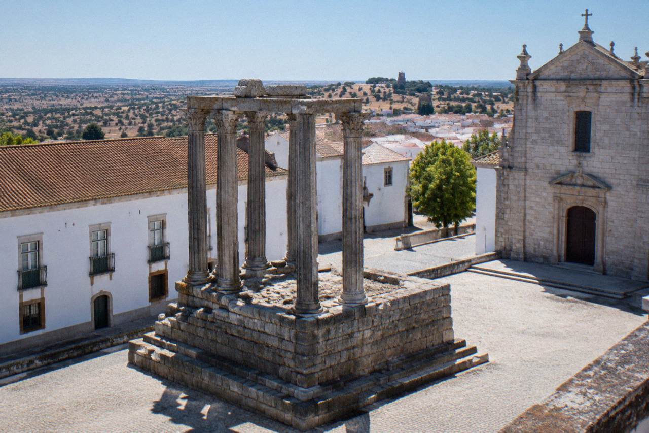Weathered Roman temple columns standing in a sunny square in Évora
