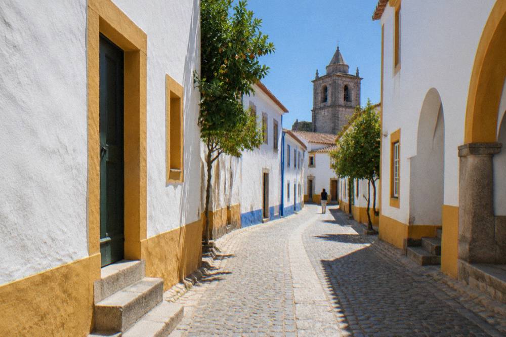 Narrow whitewashed street in the historic centre of Évora with old stone buildings