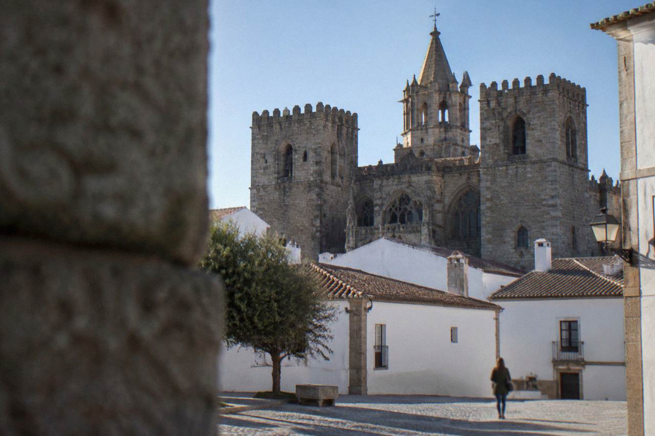 The granite west front of Évora Cathedral rising above the rooftops of the old town