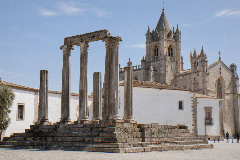The Roman temple columns in the foreground with the cathedral towers behind them at the top of the hill