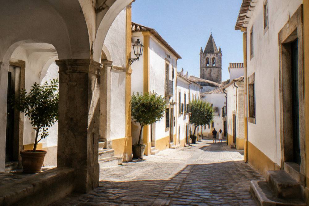 Marble-paved square with an arched arcade in Évora at midday