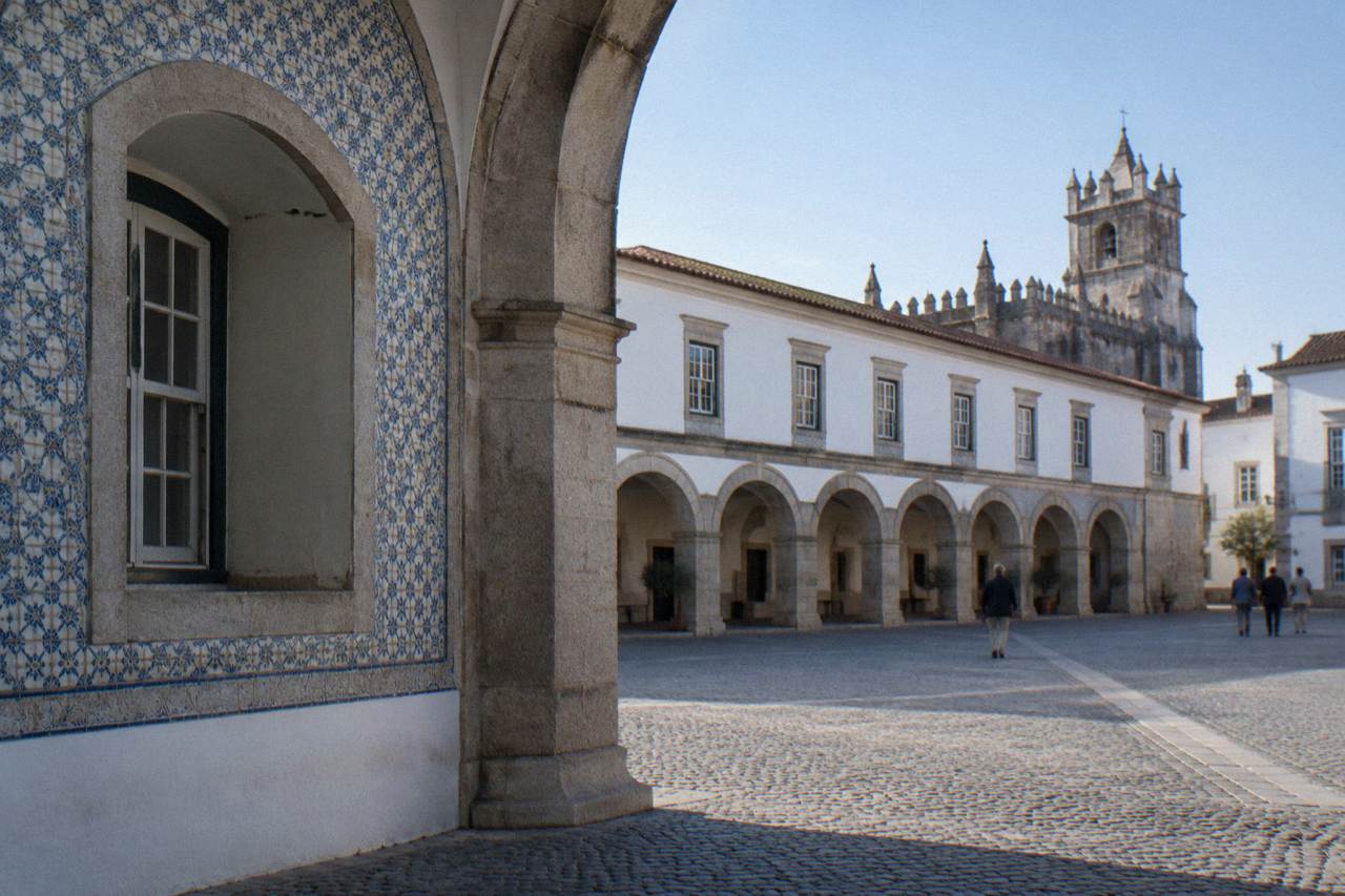 Stone archway and tiled facade of a museum building in a historic Portuguese square