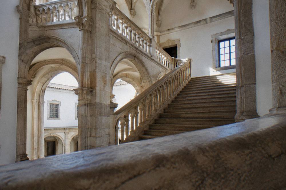 Interior stone staircase with carved arches inside a historic Portuguese museum