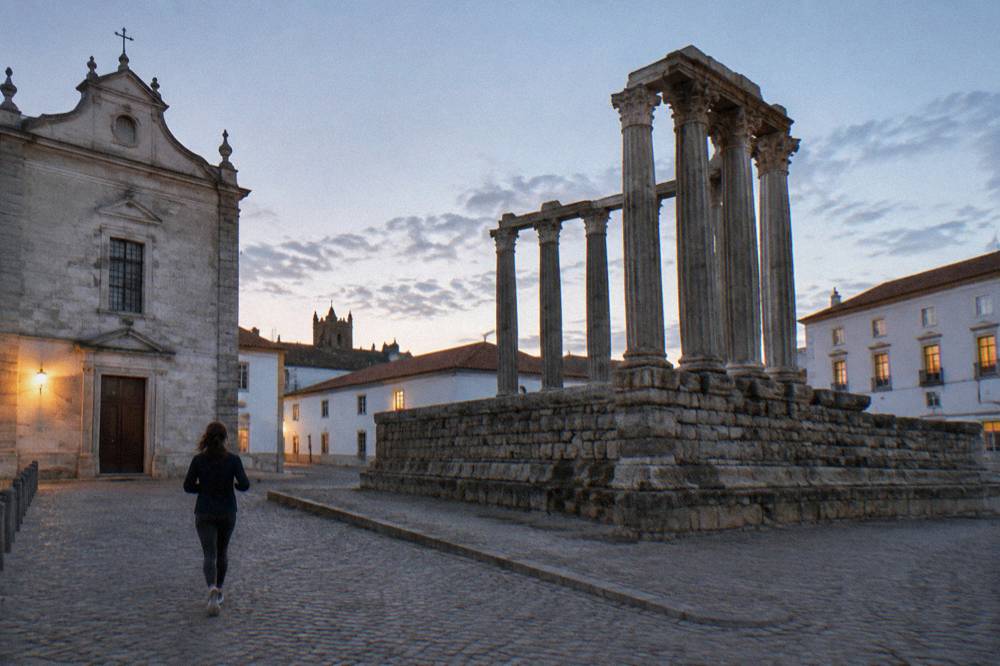 Granite columns of the Roman temple of Évora rising above a paved square in evening light