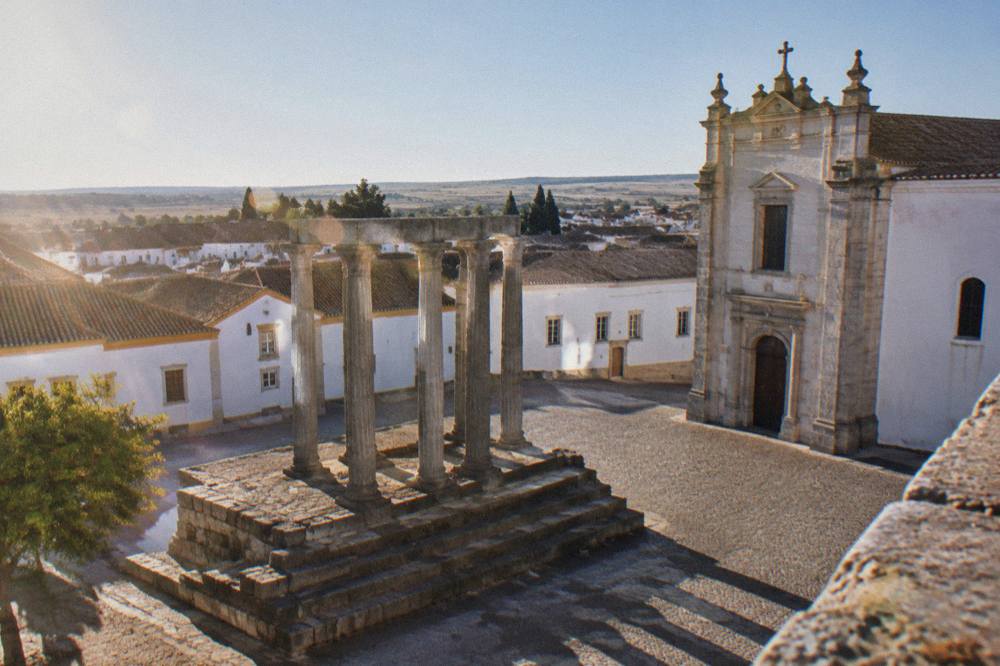 The Roman temple columns seen from a high terrace with rooftops behind them