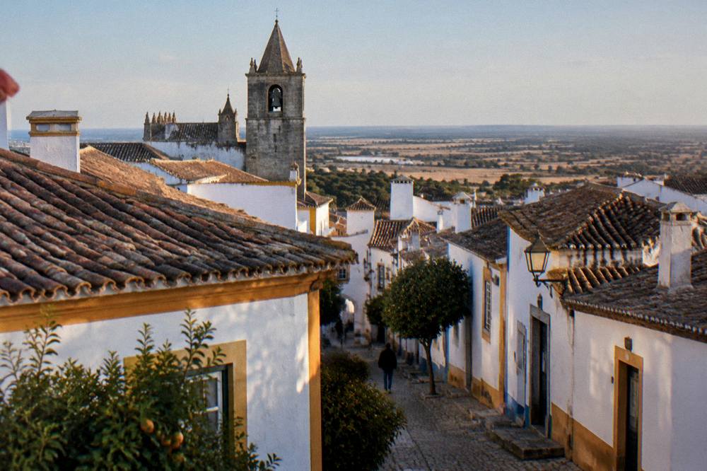 Evening view over the tiled roofs of Évora toward the open Alentejo plain