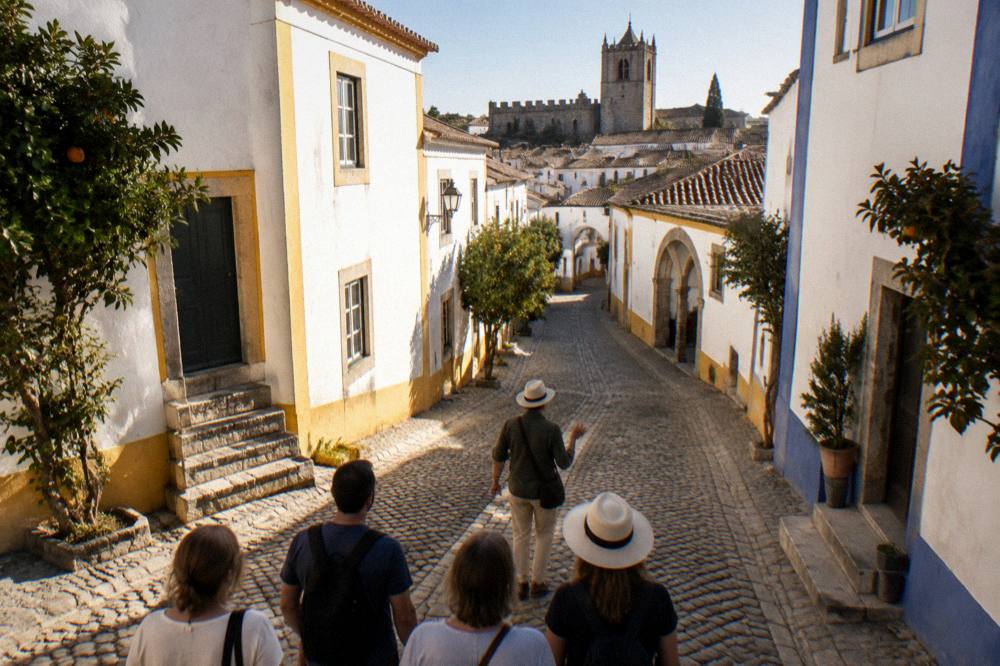 A guide leading a small group of visitors along a cobbled street in the centre of Évora