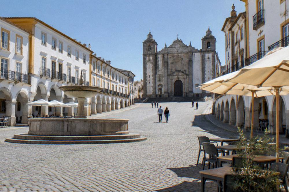 The marble arcades and café terraces of the Praça do Giraldo in Évora
