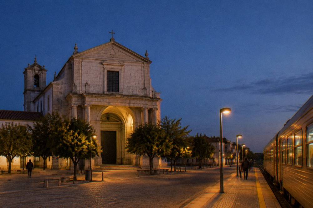 Train arriving at a small Portuguese station platform in warm evening light