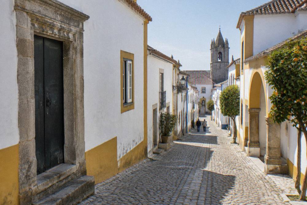 Old stone doorway with a weathered frame in a narrow street in Évora