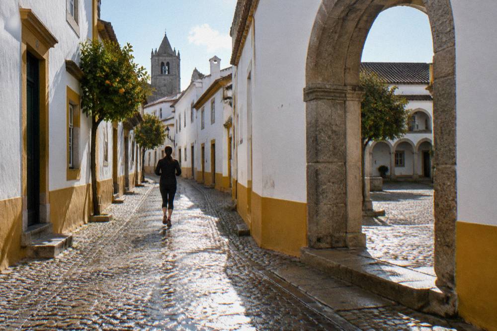 A stone archway leading into a quiet convent courtyard in Évora