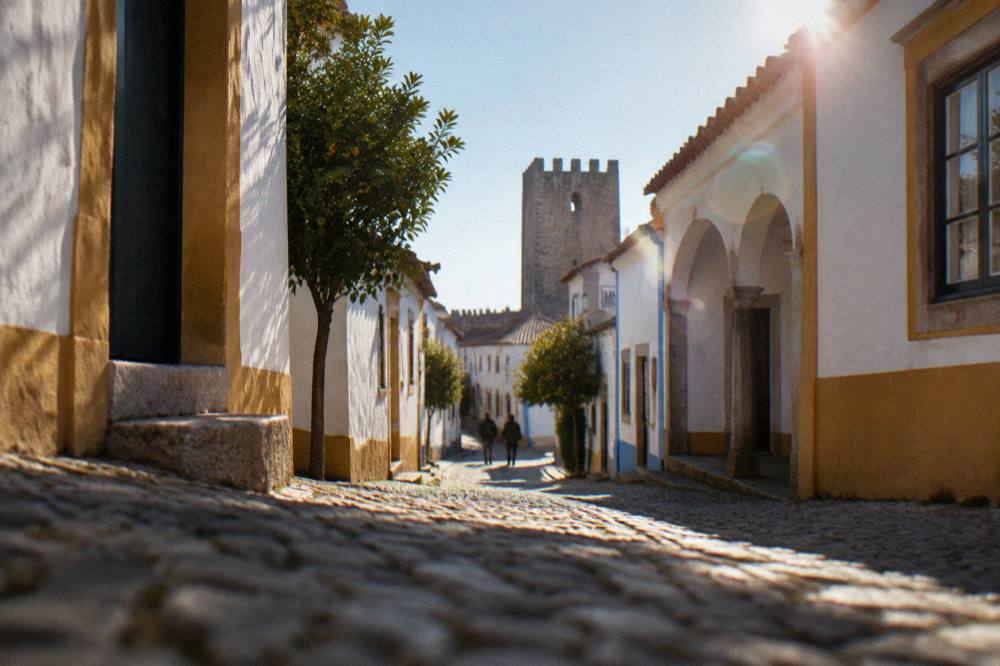 A medieval tower of the Évora walls seen from a narrow lane