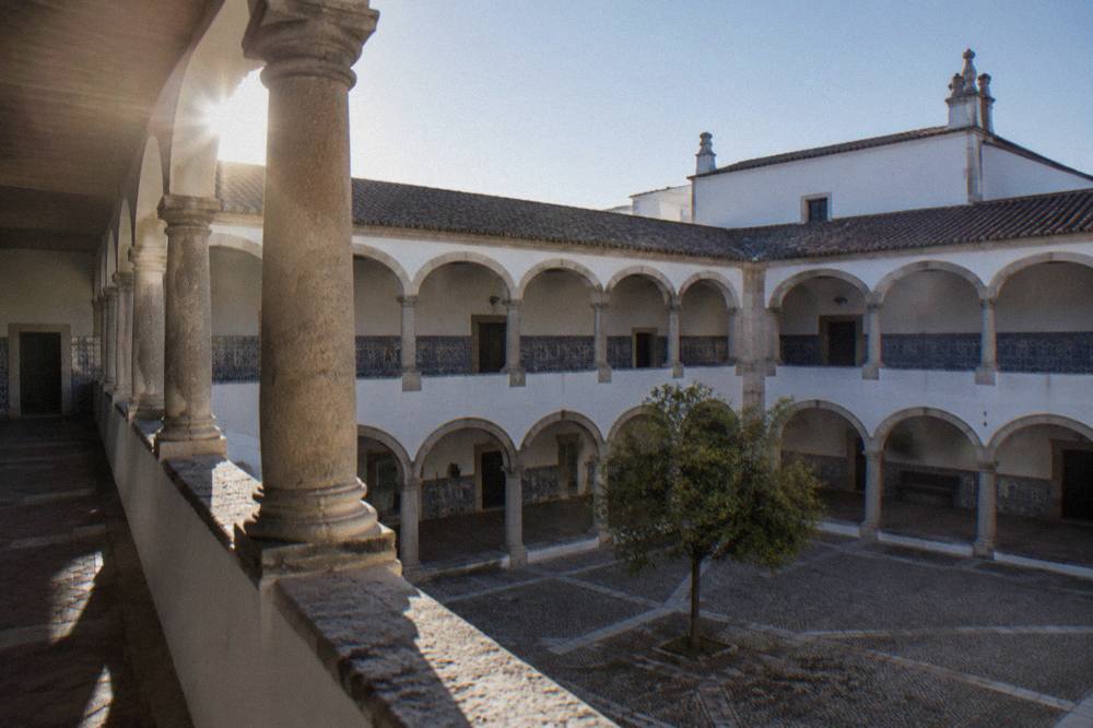 Arcaded cloister of the Colégio do Espírito Santo with stone columns and a quiet courtyard