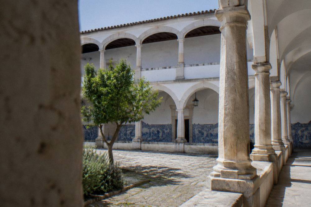 The cloister arcade of the University of Évora with sunlight on the stone columns