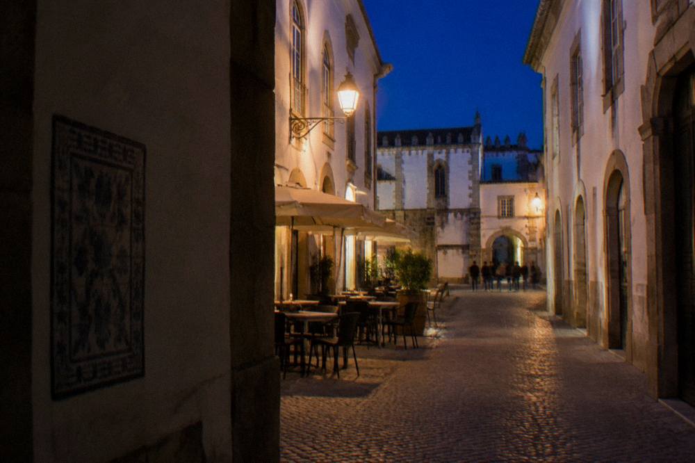 Evening light on a narrow street near the university quarter with tables outside a small restaurant