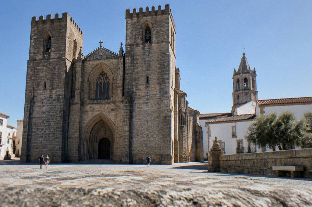 Interior of Évora cathedral cloister with gothic arches and warm afternoon light