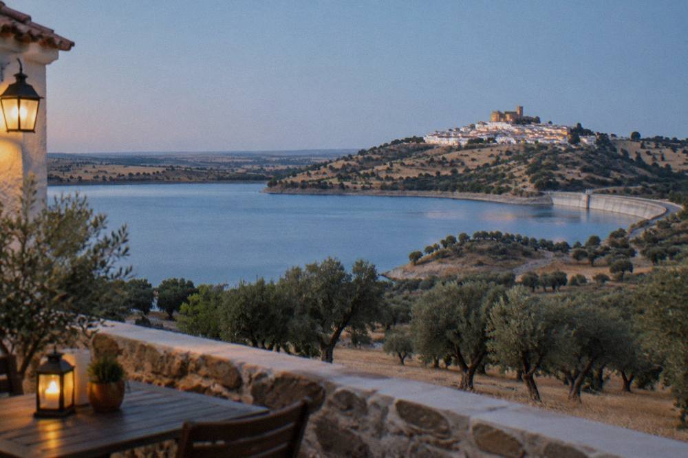 The white hilltop village of Monsaraz seen at dusk above the Alqueva lake