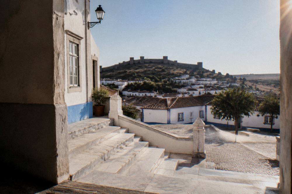 A marble staircase and white stone facade in an Alentejo town under strong sunlight