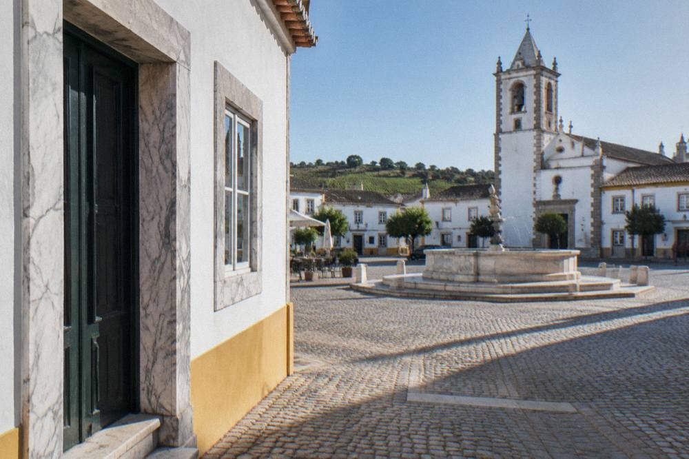 A marble doorway and window frame on a whitewashed Alentejo house