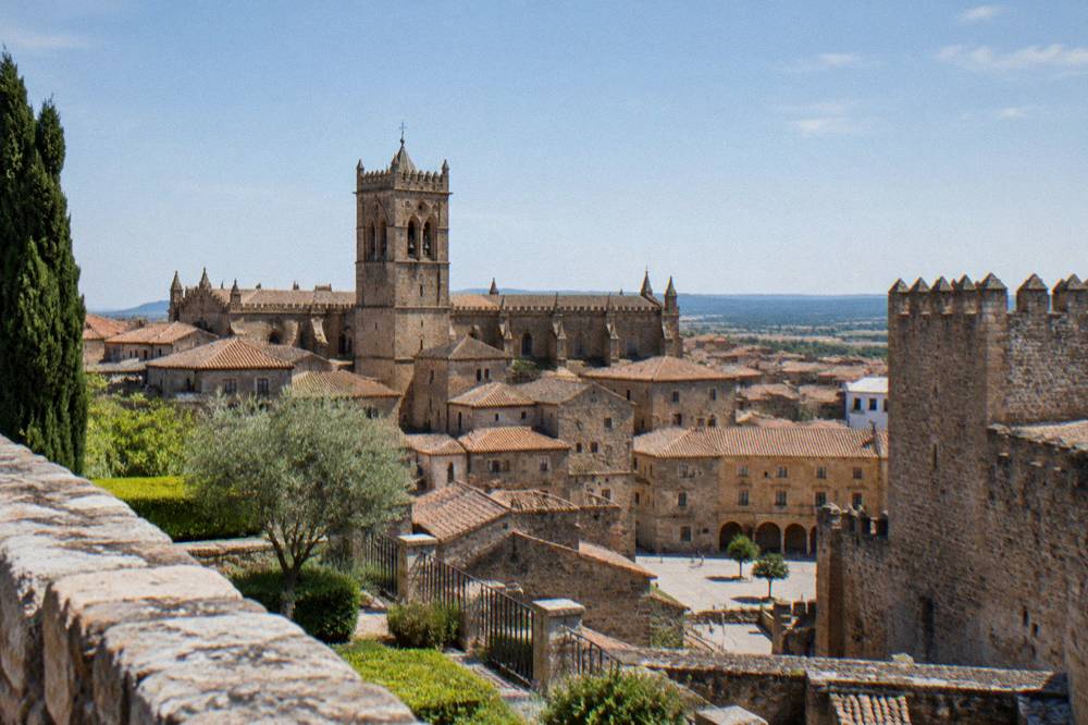 Cathedral tower and old stone buildings seen from a hilltop fortress garden