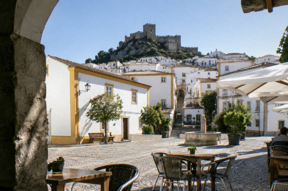 Café tables on a small sunlit square in a Portuguese town