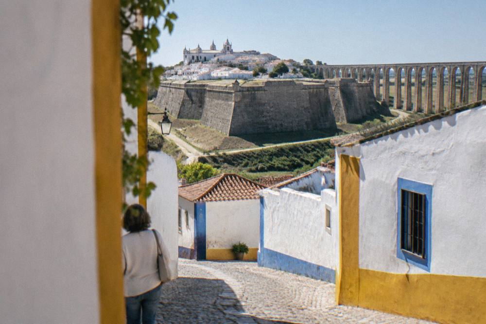 Cobbled lane inside Elvas old town with whitewashed houses and blue-yellow trim