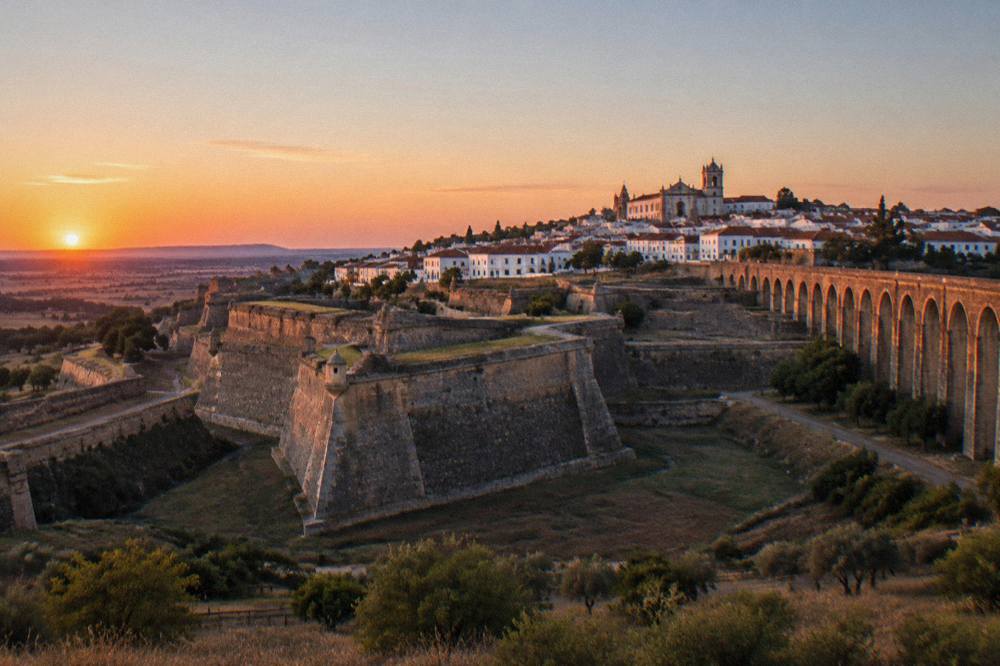 Evening view of Elvas fortifications glowing at sunset above the plain