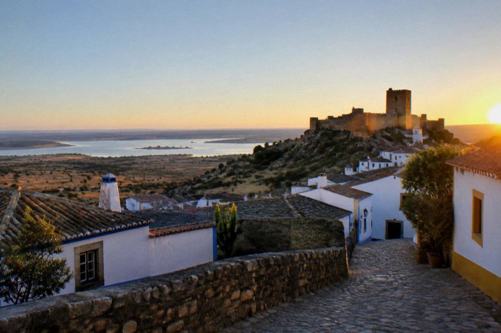 Sunset light on the castle walls of Monsaraz above the lake plain