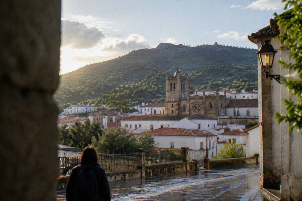 An empty country road winding through green hills toward the Serra de São Mamede