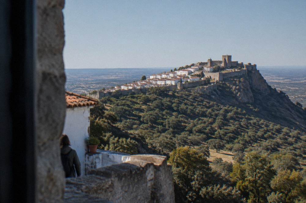 The walled hilltop town of Marvão seen from a distance across wooded slopes