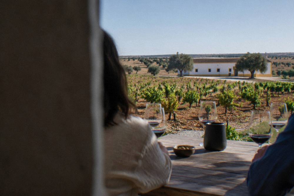 A cellar door tasting with red wine glasses on a wooden table in an Alentejo winery