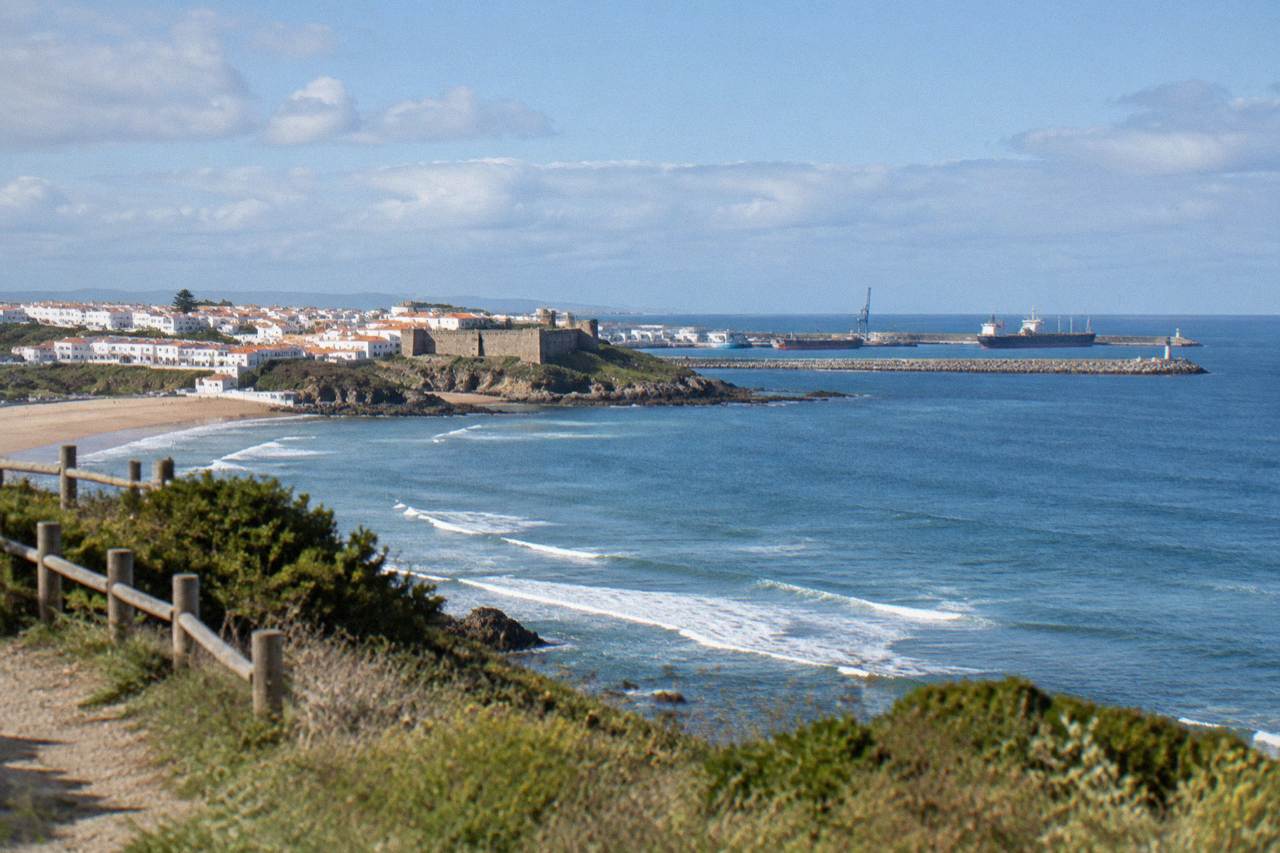 A view over the Atlantic coastline of Sines with the town's harbour in the distance on a bright day