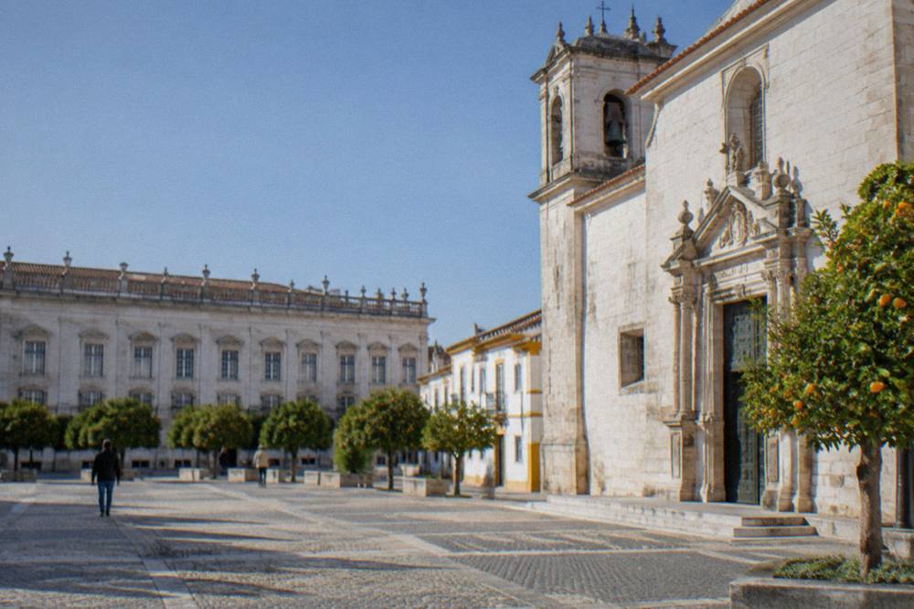 A marble church facade in Vila Viçosa with carved doorframe and bell tower in late afternoon light