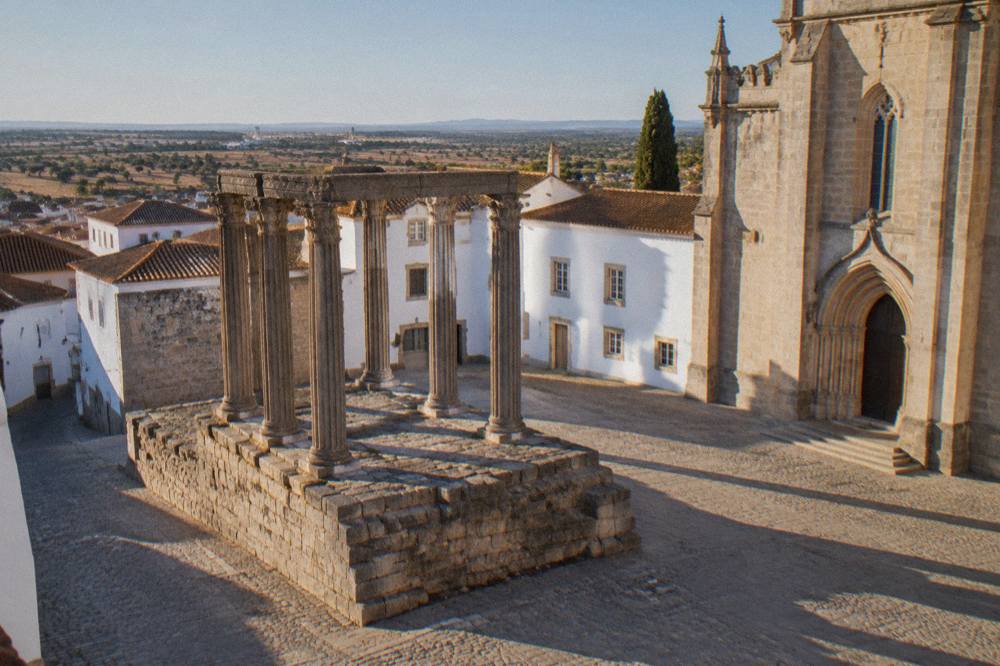 The Roman temple of Évora standing on its stone platform beside the cathedral close at golden hour